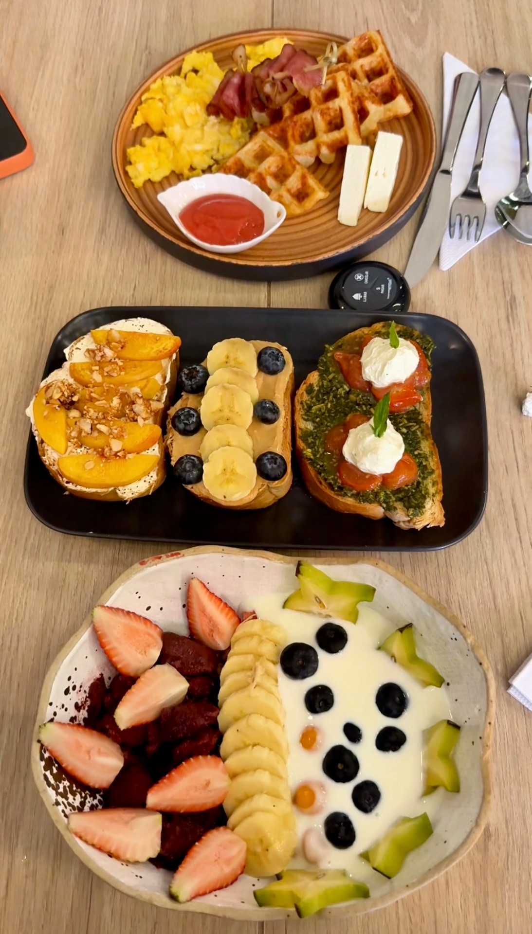 Brunch spread with waffles, open-faced toasts and a fresh fruit bowl at Pálpito Brunch in Sabaneta