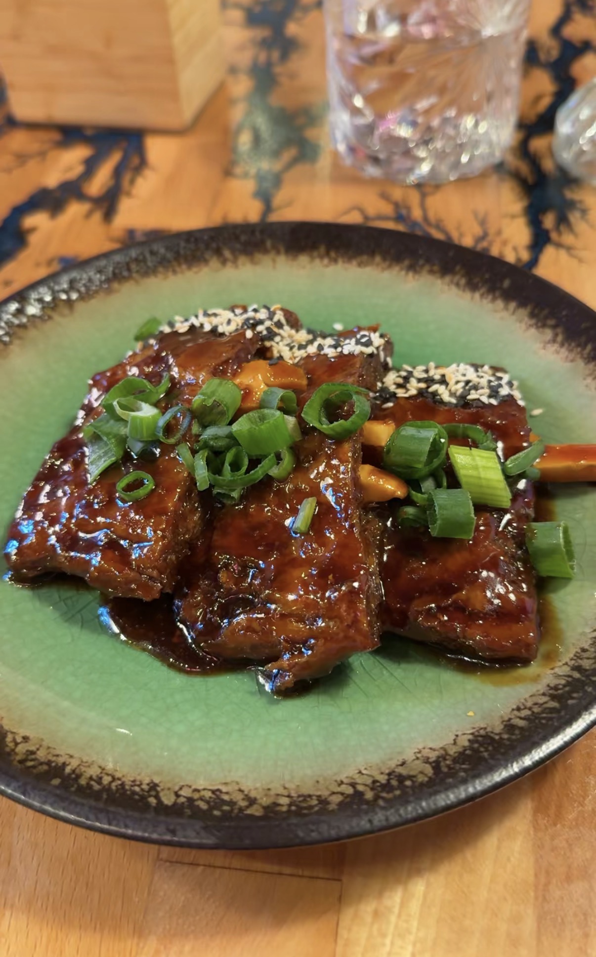 Sticky barbecue-glazed tofu with scallions and sesame seeds at Vegan AF Ramen in Kraków